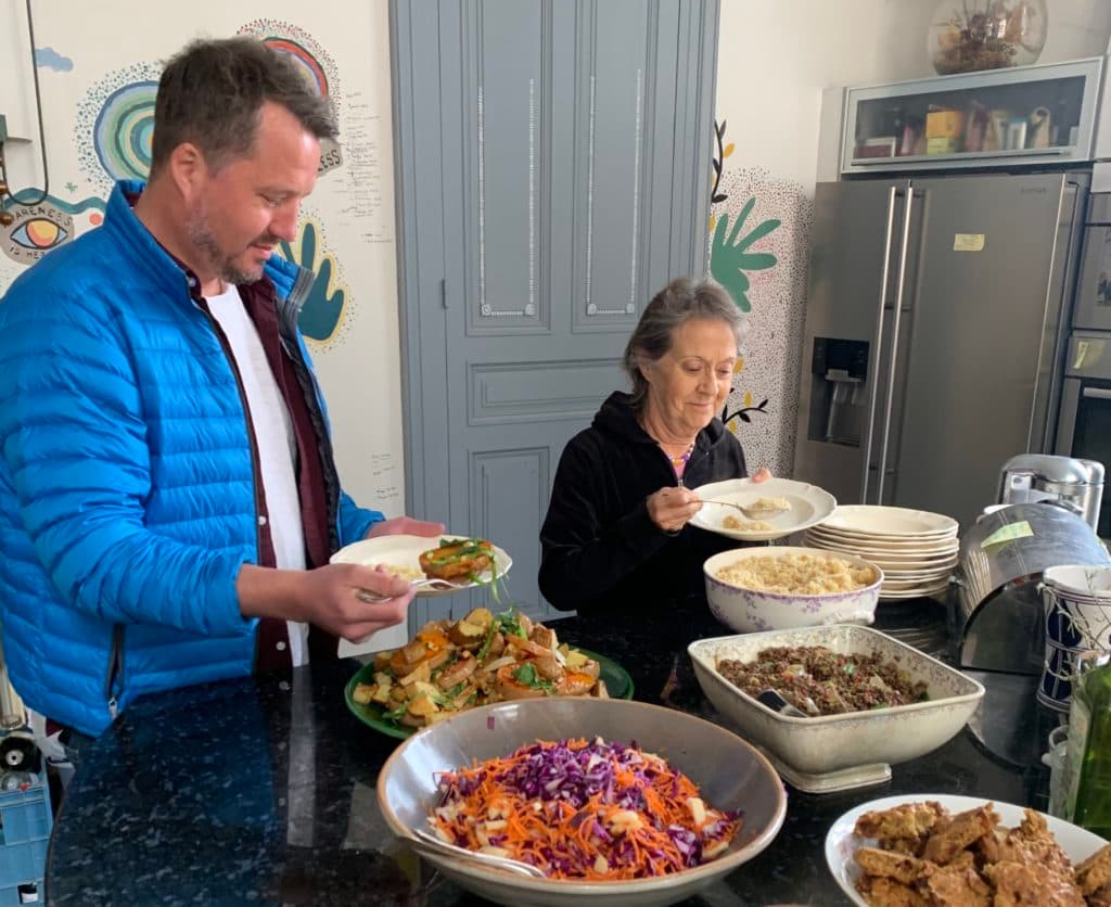 a man and a woman serve food onto plates