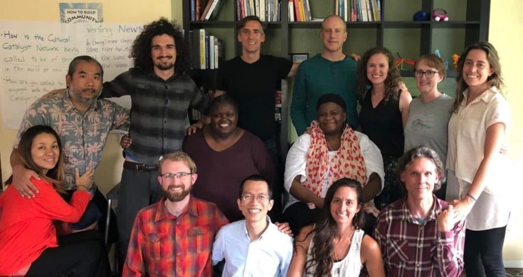 group of 14 people smiling at the camera