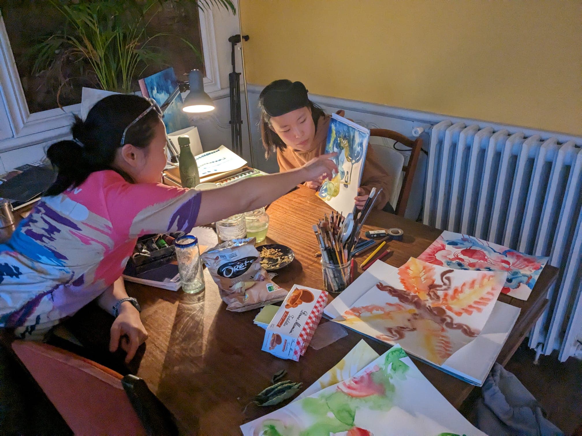 Residents sharing their watercolour work at the studio table